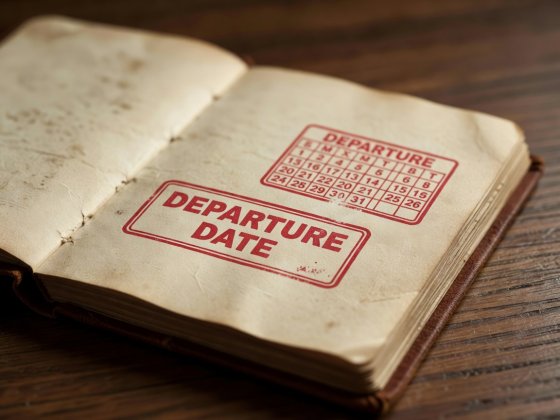 Close-up of a vintage paper pocket diary with red ink departure date stamp on an open page